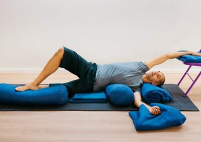 Restorative Yoga with Neal Ghoshal - side-lying over a bolster.